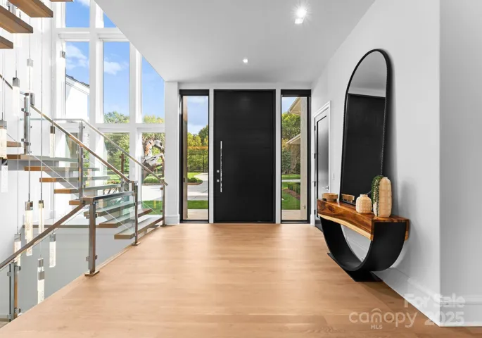Entryway with floating staircase and a 10 ft. tall and 5 ft. wide mahogany picot custom front door