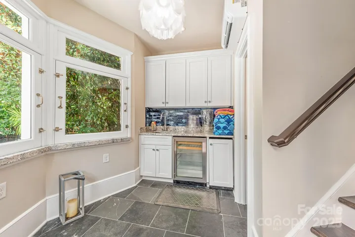 Windows open to reveal granite ledges creating a cute bar at the pool side, with full bar set up and pool bath.