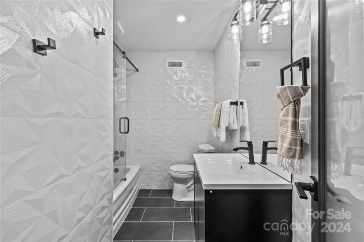 Hall Bath with custom tile surround makes  modern statement!