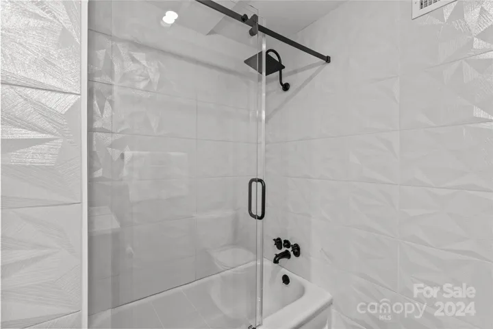 Frameless glass shower enclosure