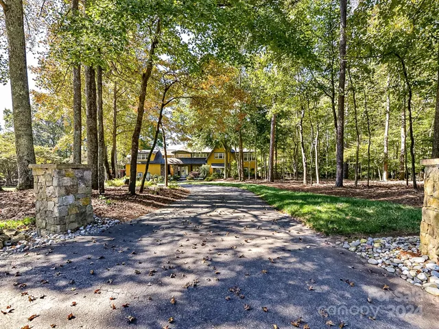 Private driveway entrance with circular driveway for easy access and plenty of guest parking.
