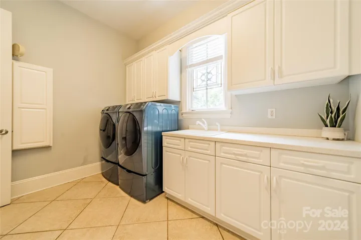 Large laundry room on main level with sink and lots of cabinet space. A