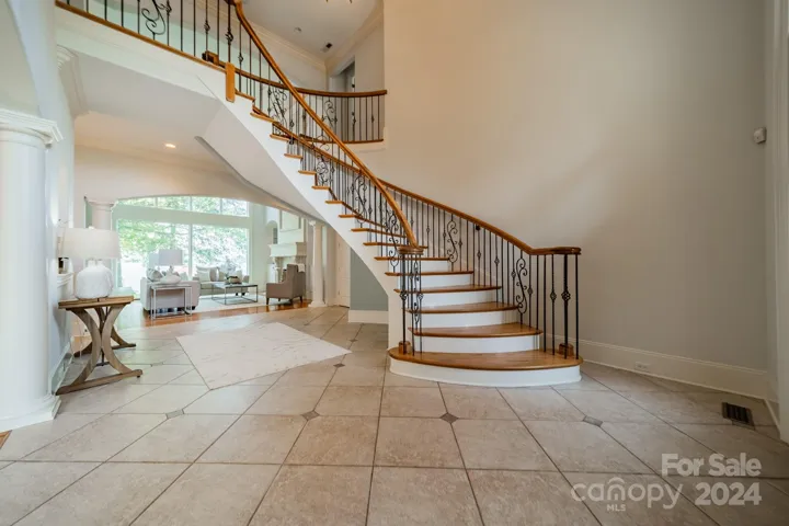 Striking staircase at the foyer entrance opens to a wall of windows to view the expansive view of the lake.