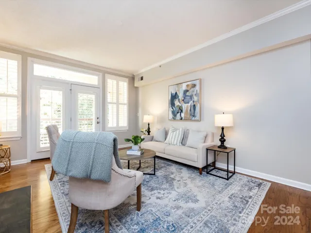 Living Room with gas fireplace, crown molding & balcony access with plenty of natural light & plantation shutters!
