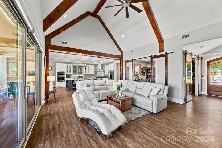 Great room with vaulted ceiling, wood beams and gas fireplace.