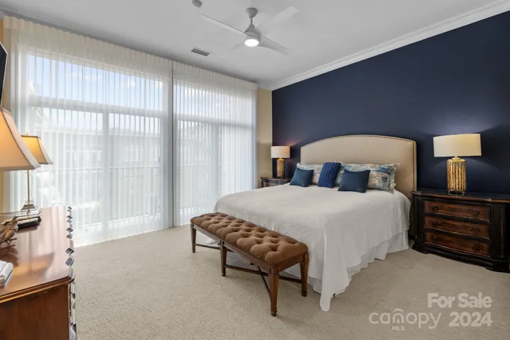 Primary bedroom has sliding glass doors (2024), new carpet (2023), Hunter Douglas Luminette motorized vertical blinds