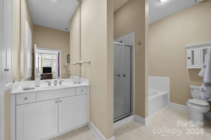 Spacious bathroom accessed from the hallway and as an en-suite from the second bedroom, features tile floors, storage, step-in shower, soaking tub, raised vanity.