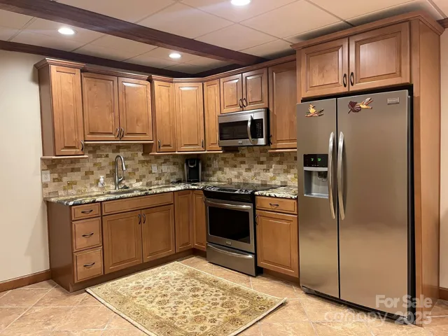 Basement kitchen has 42" cabinets, slow close drawers, granite counters w/stone backsplash. Frigidaire fridge, stove, and microwave included.