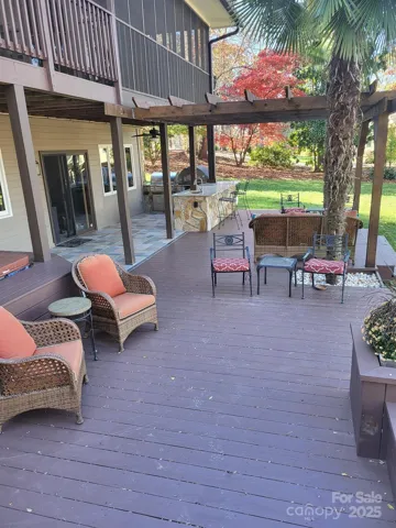 Extensive decking provides tons of different areas to entertain...patio, pergola, built-in seating & planters, and upper deck leading into screened-in-porch.