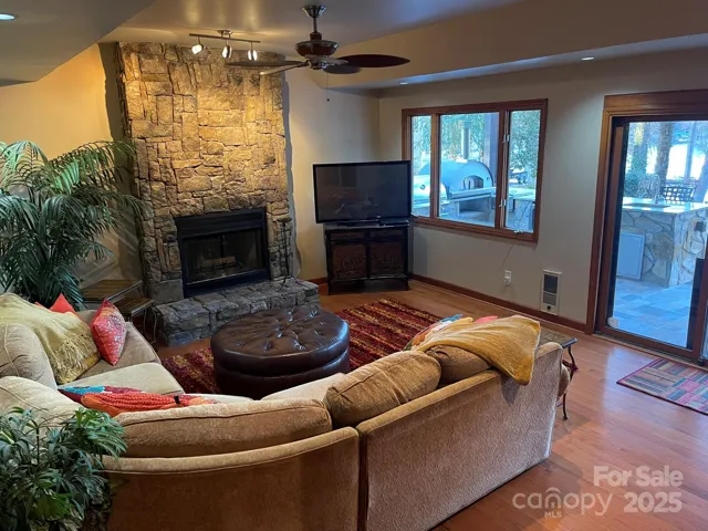 Basement living area features gas stone fireplace and tray ceiling.