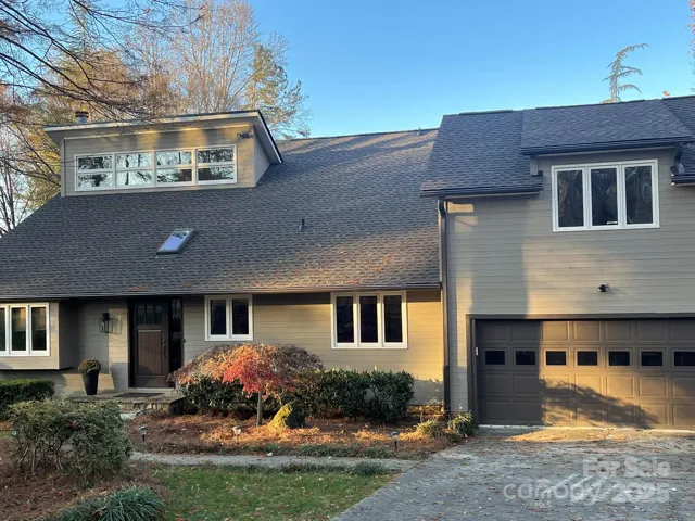 Front of cedar home all freshly painted with new roof and front door and light fixture.