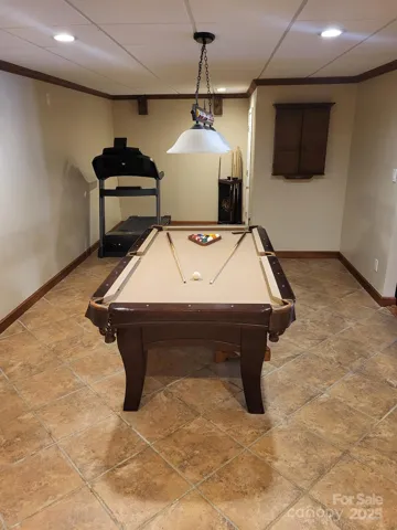 Tiled rec room has room for work out equipment as well!  Laundry also located in basement across from kitchen.