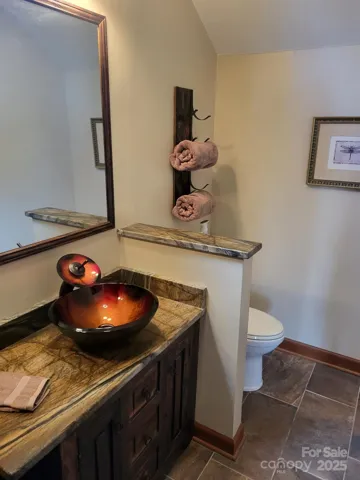 Primary leathered granite vanity with bowl sink.