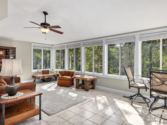 The bank of windows in the sunroom with a view of landscaping and pond.