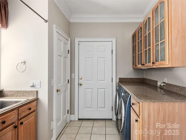 Laundry room off of kitchen with stubbed-in toilet in closet.
