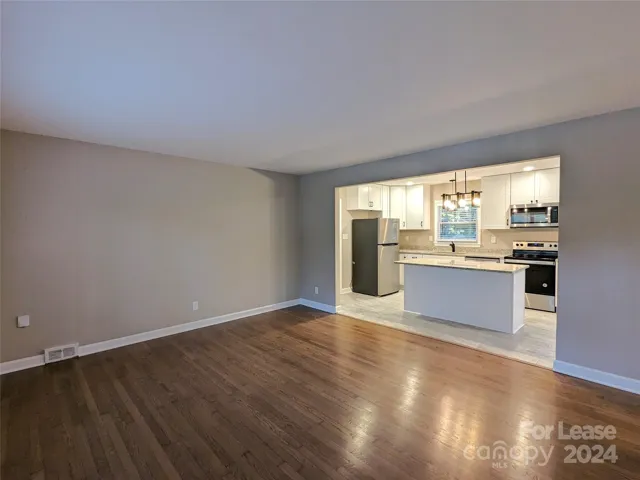 Family room has pretty hardwood floors and opens into kitchen.