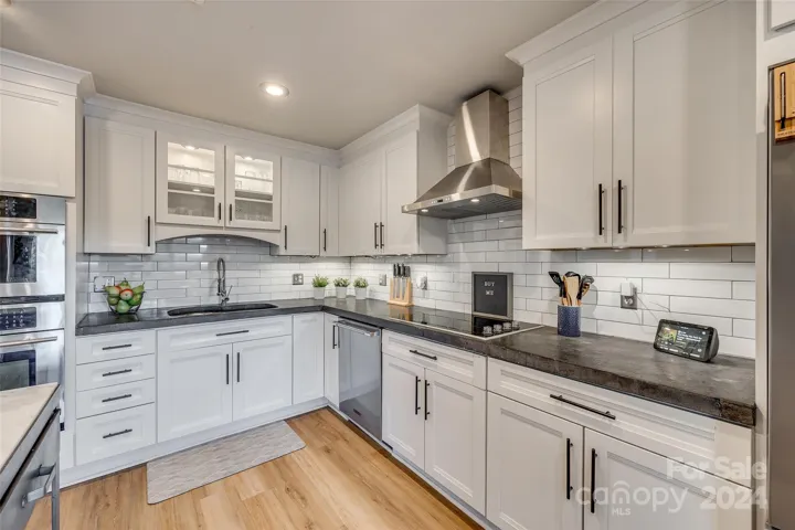 This inviting kitchen boasts a clean and contemporary aesthetic, centered around its stunning white cabinetry and durable concrete countertops.