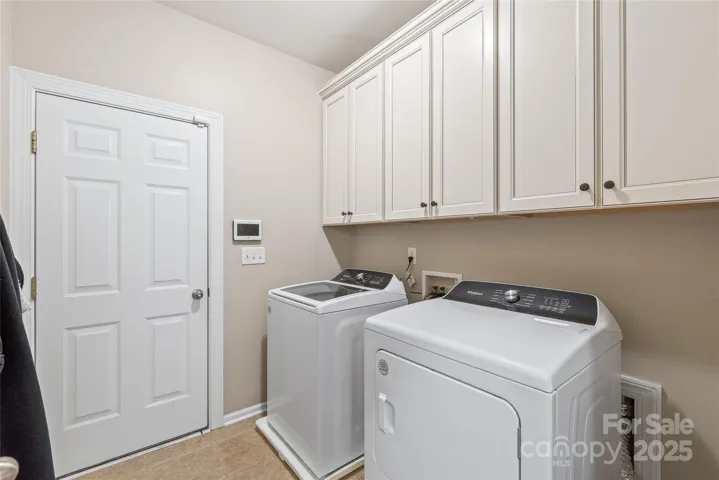 Large laundry with entrance to 3 car garage