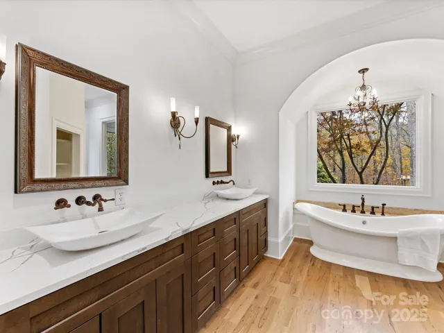 Primary Bath with freestanding soaking tub, dual vanity, sconce lighting and glass enclosed shower.