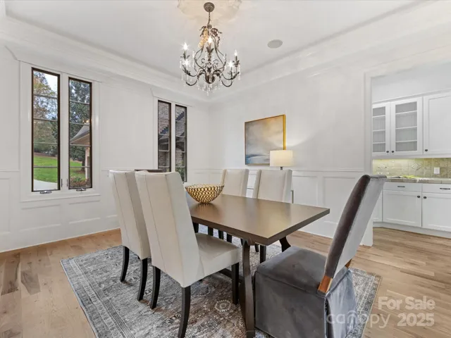 Dining Room with wainscoting, tray ceiling, uplighting and Butler's Pantry