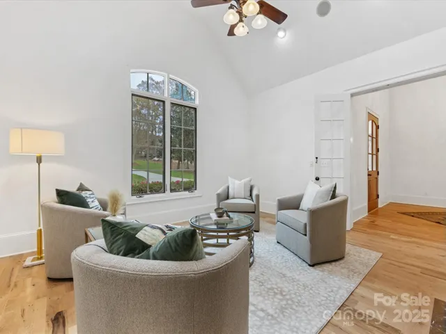 Front Sitting Room or Office with vaulted ceiling, glass entry doors, gas fireplace and wet bar