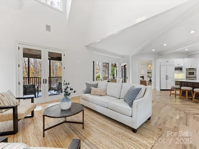 Great Room with vaulted ceiling, gas fireplace opens to Kitchen and Breakfast area as well as the Screened Porch