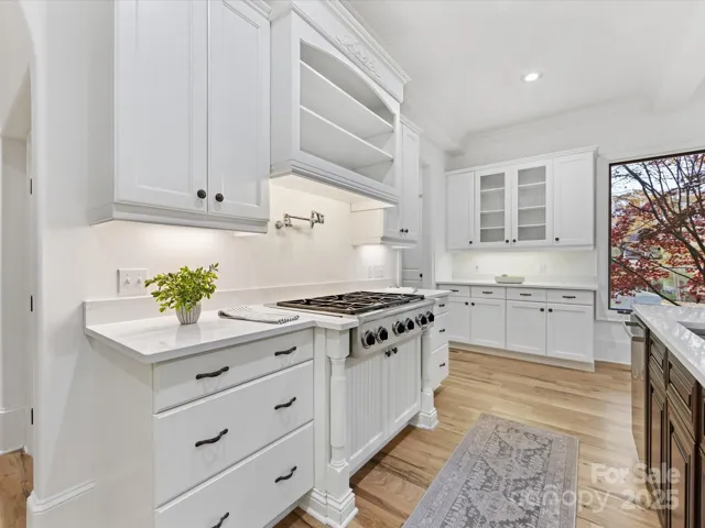 Kitchen with quartz counter, Dacor gas cooktop, double ovens and freshly painted cabinetry