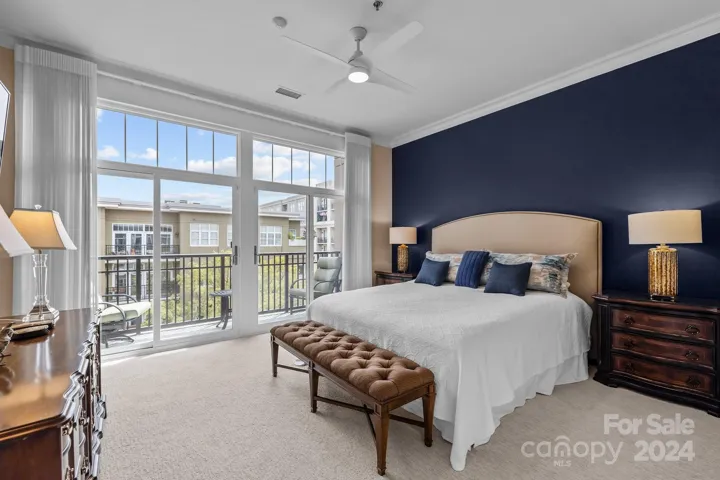 Serene and spacious primary suite with its own balcony, large floor-to-ceiling windows/sliding glass doors. Room for a king-size bed.