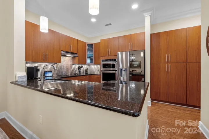 The kitchen is a standout feature of the home, featuring granite counters, stainless steel appliances, tile backsplash, generous counter space, and tons of cabinet space for storage.
