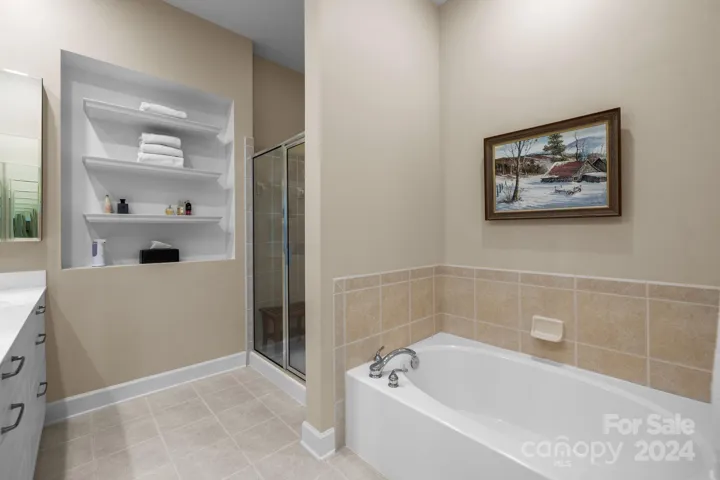Primary bathroom features a step-in shower with tile surround, soaking tub with tile surround and a private water closet.