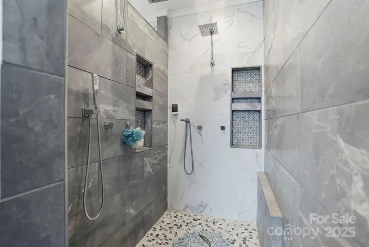 Walk-in shower with sleek tile accents and shower settings