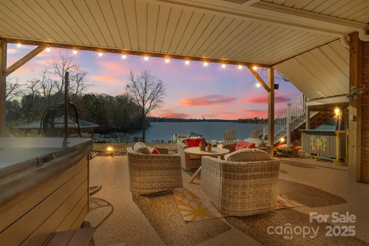 Backyard lake views from covered patio including hot tub