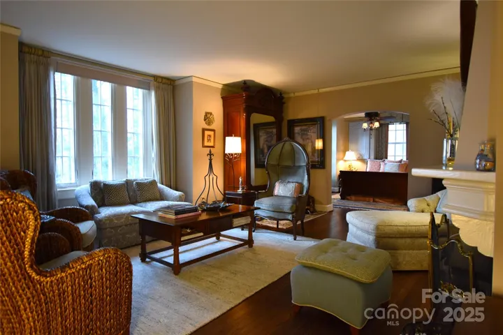 Living room with original fireplace and triple window bay in B9, currently utilized as the primary suite.