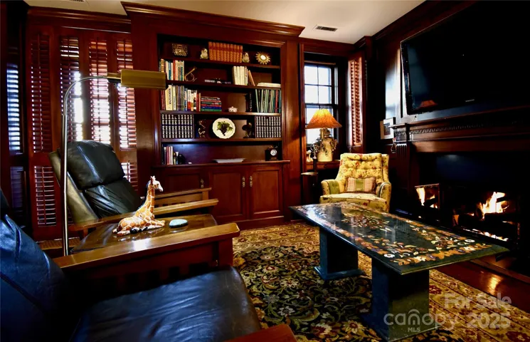 The rich wood paneled library of B10 features an original fireplace and has gas logs, perfect for a fireside read.