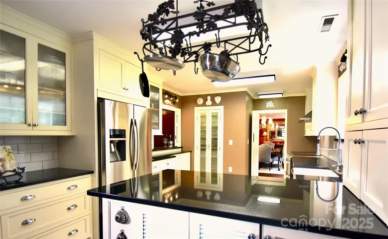 Glazed double door upper cabinets complement the pantry doors.