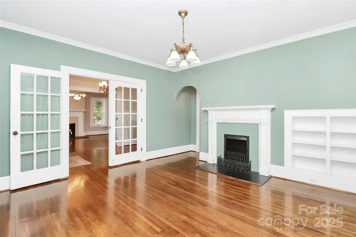 2nd view of the office with an arched doorway into the primary bedroom.