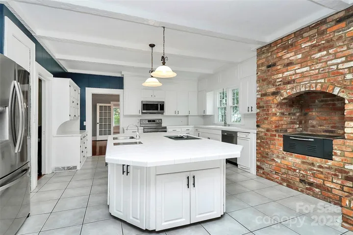 An indoor grill with an exhaust fan to the exterior in this amazing kitchen.