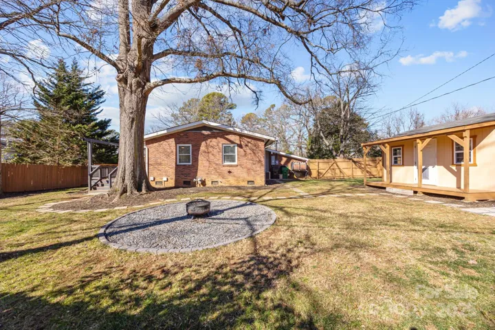Large shady backyard with firepit circle