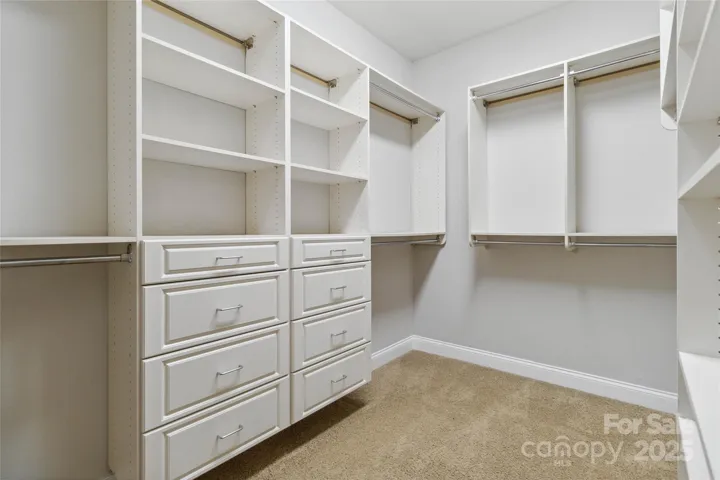 Primary closet with custom shelving and hanging space