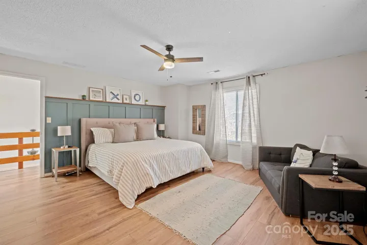 Spacious Primary Bedroom features ceiling fan/light, custom molding, LVP floors, private bath & walk in closet!