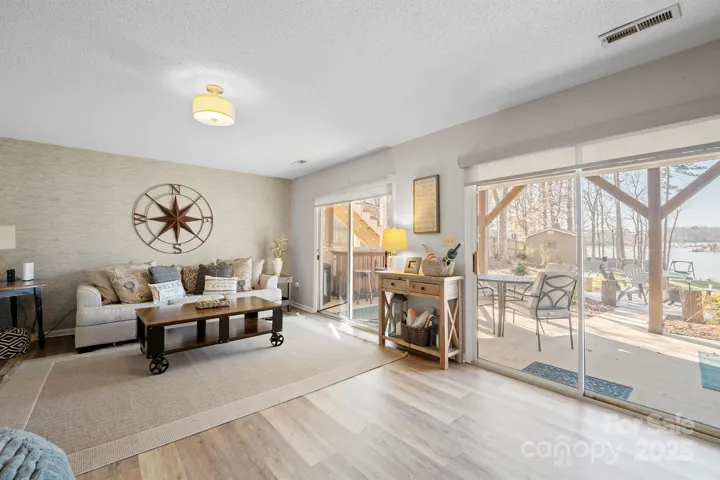 Basement Level Living Room with LVP floors & walk out access to covered patio with Amazing Lake Views!