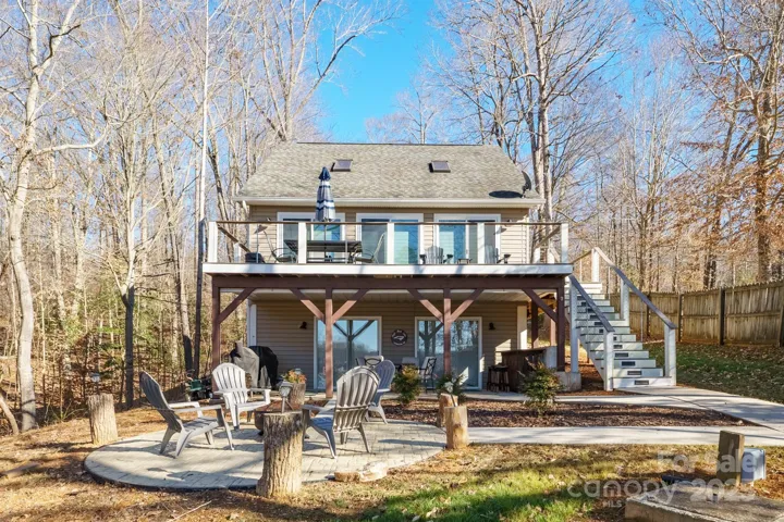 Exterior Back View of Home with covered patio, deck & fire pit area for plenty of places to relax, unwind & enjoy your tranquil surroundings & perfect water views!