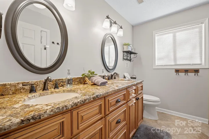 Basement Level Full Bath with dual, granite vanity, tiled shower & tile floors!