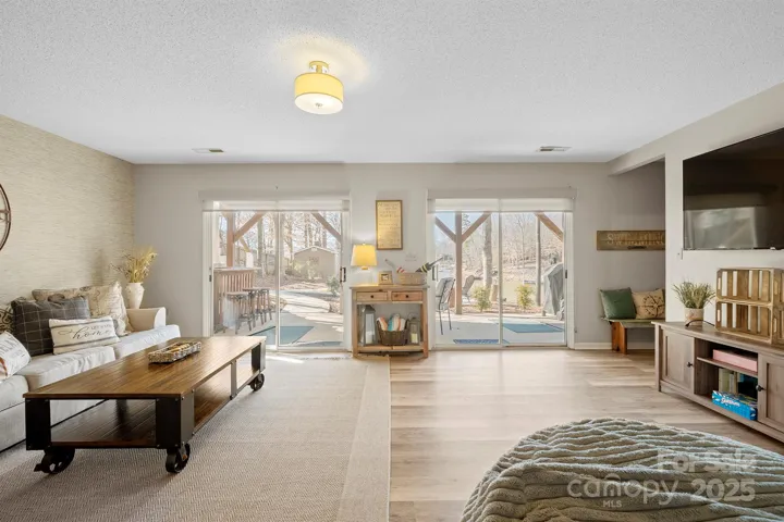 Basement Level Living Room with LVP floors & walk out access to covered patio with Amazing Lake Views!