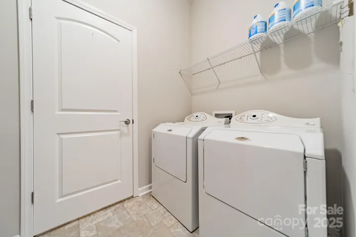 Main level laundry room includes cabinets and a folding counter (not shown). The door leads to a walk-in storage room.