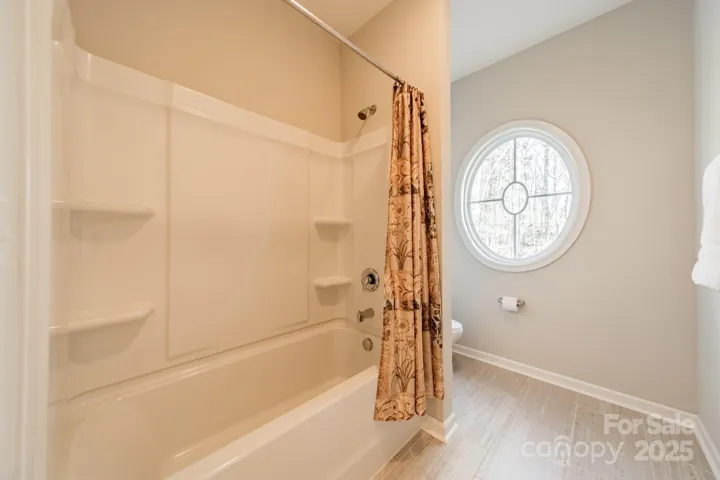 Part of the 2nd floor Jack and Jill bath, featuring the round window overlooking the pretty front yard