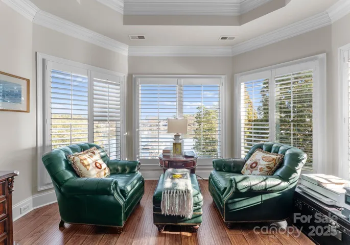 Spacious bedroom, currently utilized as an office, offering serene lake views that enhance the room’s tranquil ambiance. The expansive windows invite natural light, creating an ideal setting for both productivity and relaxation.