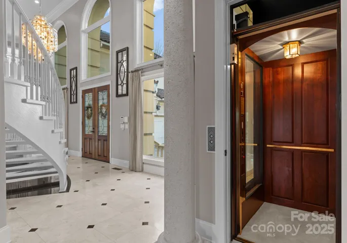 The elevator, accessible from the foyer, features elegant glass panels that allow a view into the cabin. This stylish lift provides convenient access to all three levels of the home, blending both functionality and design.