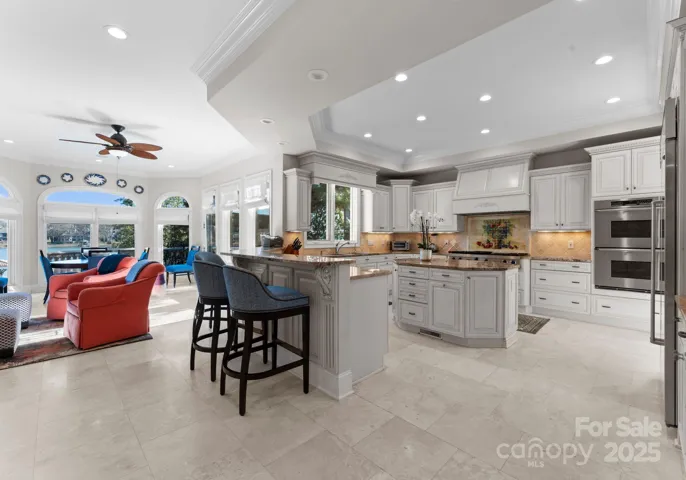 The kitchen features an open layout, seamlessly integrating a cozy seating area with a fireplace and a dining nook.