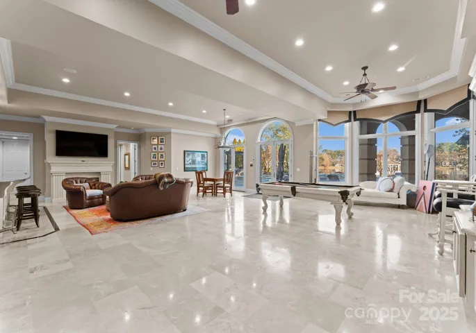 The expansive lake level boasts a cozy fireplace, a refined billiard area, and an inviting sitting space, creating the perfect blend of relaxation and entertainment.